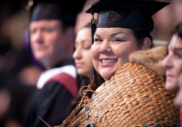 Smiling graduate in traditional indigenous weaving